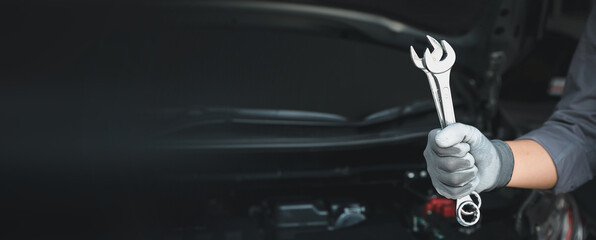 Close-up hand auto mechanic using the wrench to repairing car engine problem. Concepts of check and fix car and maintenance servicing.