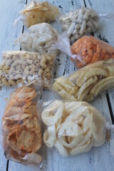 Various kinds of Indonesian snacks in plastic bags on the table

