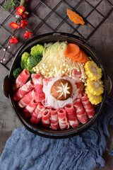 Fat beef rolls and vegetable ingredients placed in black hot pot