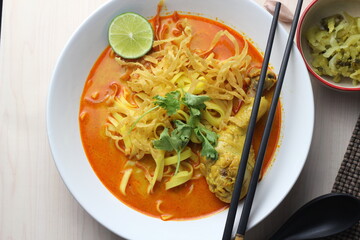 Northern Thai food (Khao Soi), Spicy curry noodles soup with coconut milk and chicken drumstick, Local Thai food, Table top view