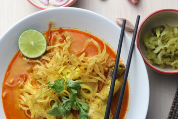 Northern Thai food (Khao Soi), Spicy curry noodles soup with coconut milk and chicken drumstick, Local Thai food, Table top view