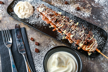 Oreos and Brownie Waffle Stick with chocolate, whipped cream, knife and fork served in dish...