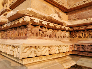 Intricate ancient stone carvings on a temple base