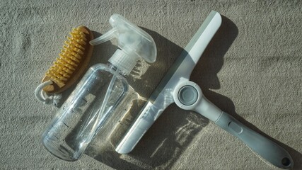 Cleaning kit. squeegee to wash a window, brush and spray bottle on a gray background