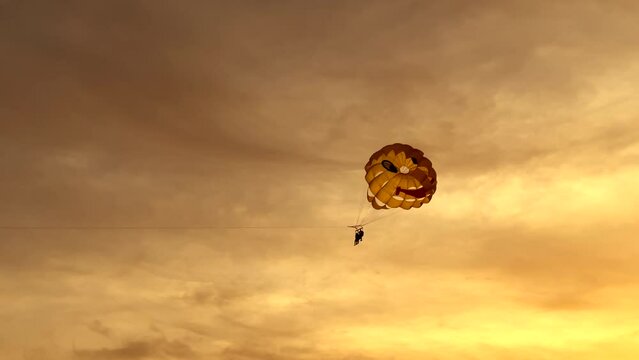 Summer beach vacation parasailing fun during sunset
