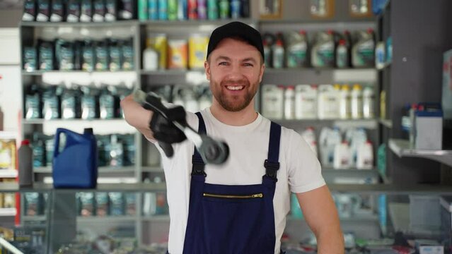 Funny auto parts seller imitates the blows of nunchuck or kung fu in car shop