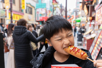 横浜中華街で食べ歩きをする日本人の男の子