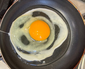 The egg is fried in a frying pan. Close-up