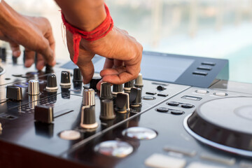 A boy operate turntable dJ mixer on a white table