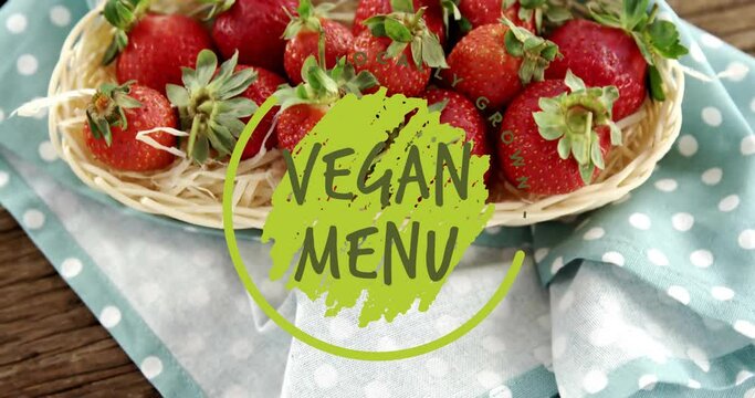 Animation of vegan menu text over strawberries on table