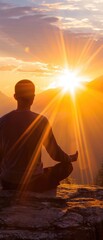 A man meditates at dawn in the mountains. Guy doing yoga in the mountains at sunrise