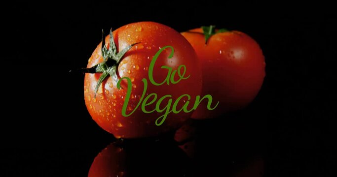 Animation of go vegan text over tomatoes on black background