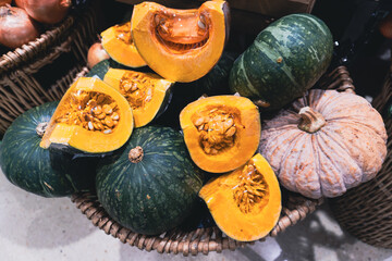 A colorful autumn harvest of a ripe orange pumpkin and green squash sits on a table - 749183826
