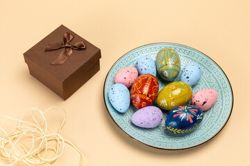 Dish with colored Easter eggs and a gift box.