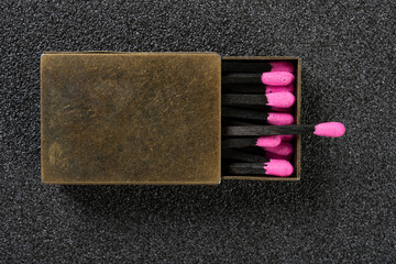 top view copper matchbox with pink color match sticks at horizontal composition