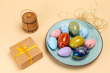 Dish with colored Easter eggs and a gift box.