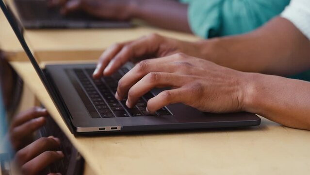 Close pp of businessman typing on laptop computer keyboard in modern office - shot in slow motion