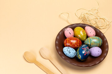 Dish with colored Easter eggs and wooden spoons.