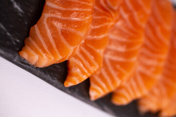 Close-up view of a fresh raw salmon fillet with delicate flavor and pink color on a white background