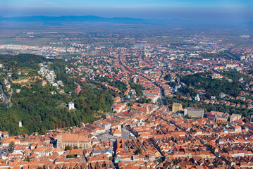 a large city with lots of brown roofs and trees in the background