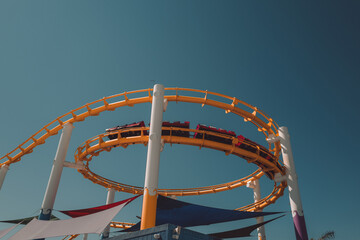 Moving roller coaster in an amusement park during the summer daytime. Entertainment, fun and...