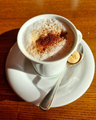 Cup of coffee cappuccino with foam oil and biscuit