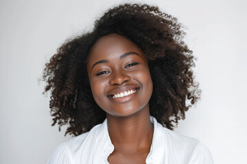 Confident young woman smiling against neutral background. Positive emotions and self-confidence.