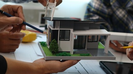 Fototapeta premium Closeup of hands engineer and architect team discussed about construction and architectural drawings works.