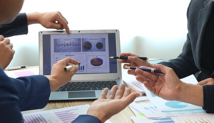 Close up of hands of business people working together in a conference room, brainstorming, discussing and analyzing and planning business strategies.