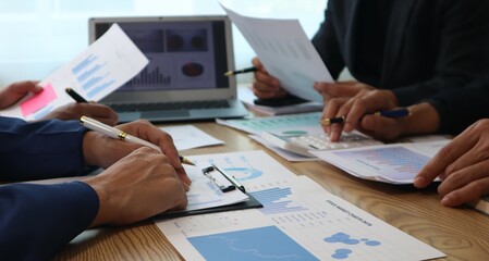 Close up of hands of business people working together in a conference room, brainstorming, discussing and analyzing and planning business strategies.