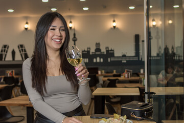 Smile, happy and coffee shop young woman enjoying a glass of wine in a restaurant or cafe on her lunch break. Portrait of happy customer drinking wine with happiness