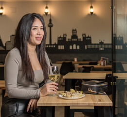 Smile, happy and coffee shop young woman enjoying a glass of wine in a restaurant or cafe on her lunch break. Portrait of happy customer drinking wine with happiness