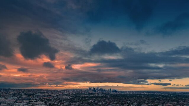 Dramatic stormy sunset clouds over city of Los Angeles skyline cityscape. Aerial timelapse view.