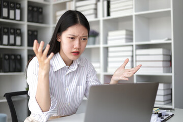 Serious Asian businesswoman stressed with paperwork in the office.