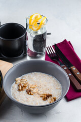 English breakfast oatmeal with walnuts, peanuts and a glass of water.