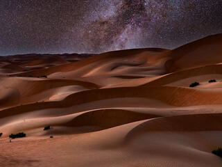 Fototapeta na wymiar Winter side of the Milky Way over desert sand dunes