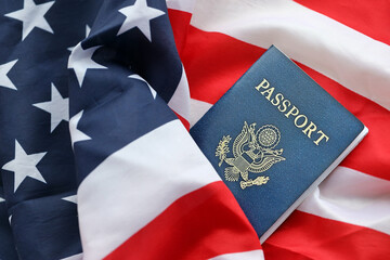 Blue United States of America passport on national flag background close up. Tourism and citizenship concept