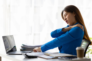 Woman who are serious about working in the office are having aches and pains in their shoulders and waist, office syndrome.