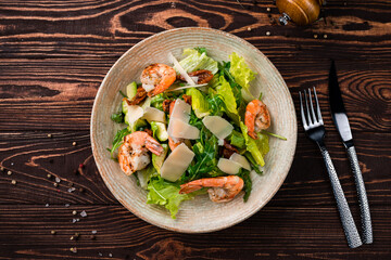 Salad of shrimp, avocado, sun-dried tomatoes, parmesan cheese, lettuce and arugula.