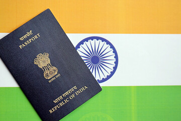 Blue Indian passport on national flag background close up. Tourism and citizenship concept