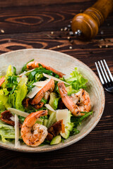 Salad of grilled shrimp, avocado, sun-dried tomatoes, parmesan cheese, lettuce and arugula.