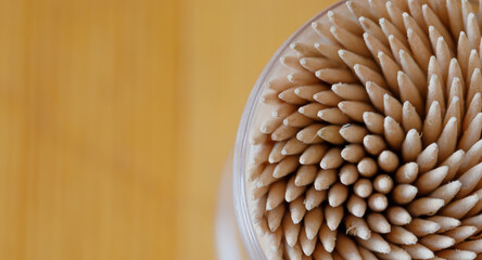 Toothpicks in a transparent container, close-up, top view, blurred background