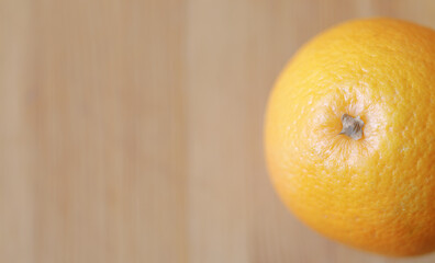 Fresh orange on a blurred wooden background, top view,