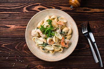 Lunch pasta with shrimp, cream sauce and arugula.