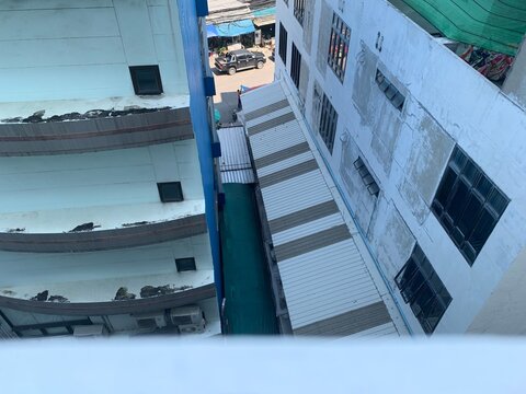 The small crawl space between two buildings with roof in Bangkok Thailand, photo from bird eye view 
