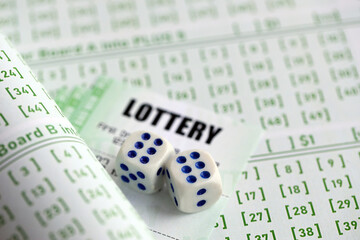 Lottery tickets and dice on blank bills with numbers for playing lottery close up