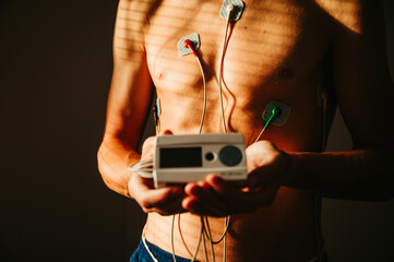 Vital Signs in Focus: Young Man Monitored by EKG for Comprehensive Insight into Heart Health and Well-being - 749256477