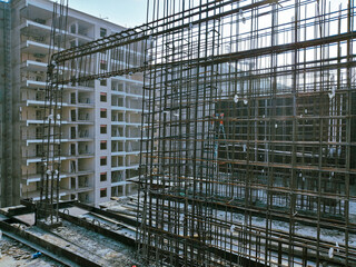 A construction site with scaffolding and a crane. Scene is one of progress and hard work