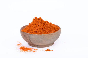 Przyprawa papryka słodka w proszku w drewnianej miseczce na białym tle