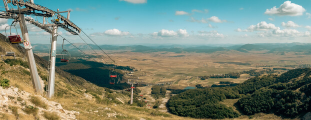 Ski lift high in the mountains with panorama on plateau with forest and meadows, Durmitor, Montenegro